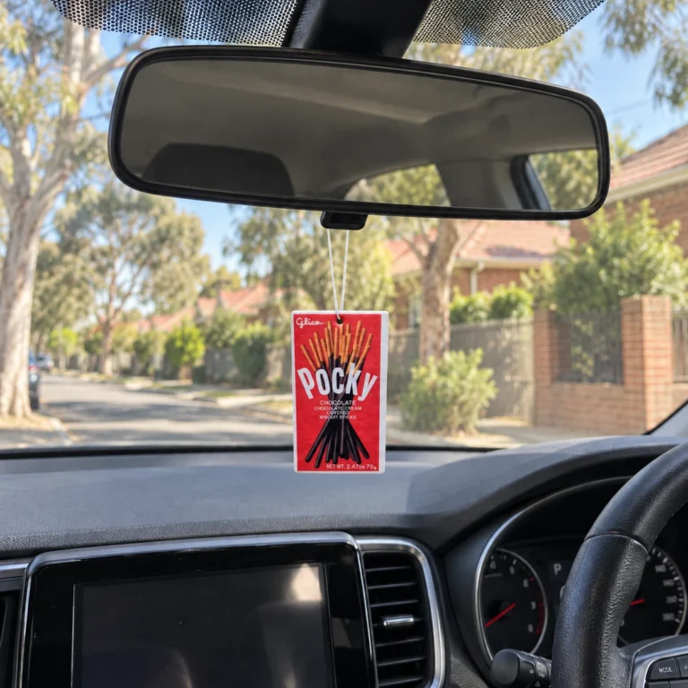 Auto Candy Pocky Car Air Freshener Strawberry Fragrance hanging from a rear-view mirror in an Australian car — product mockup